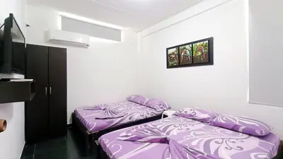 two beds in a room with purple sheets at Apartamento Aeromar, Santa Marta in Santa Marta