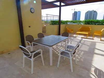 a table and chairs sitting on a patio at Apartamentos Oceana - Cerca al Buenavista by SOHO in Barranquilla