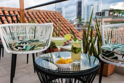 a glass table with two drinks on a balcony at Hotel Casa La Fe in Cartagena de Indias