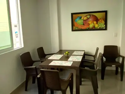 a dining room table and chairs with a painting on the wall at Hostal Casa de Barajas in Cartagena de Indias