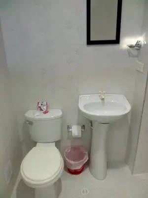 a white bathroom with a toilet and a sink at Hostal Casa de Barajas in Cartagena de Indias