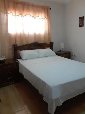 a bedroom with a large white bed with a window at Hostal Casa de Barajas in Cartagena de Indias