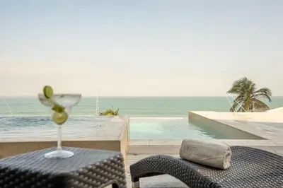a glass of wine sitting on a chair next to a pool at Hotel Cartagena Dubai in Cartagena de Indias