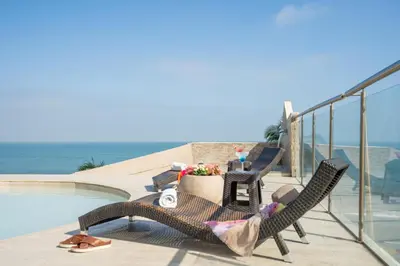a woman sitting in a chair next to a pool at Hotel Cartagena Dubai in Cartagena de Indias