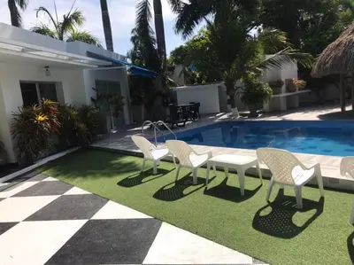 a patio with a table and chairs next to a swimming pool at Carmela Beach in Tubará
