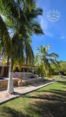 a couple of palm trees in front of a building at Casa de Playa Moñitos Laguito in Moñitos