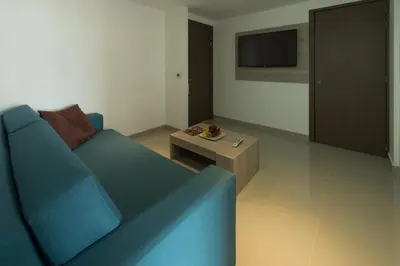 a living room with a blue couch and a coffee table at Hotel Barranquilla Plaza in Barranquilla