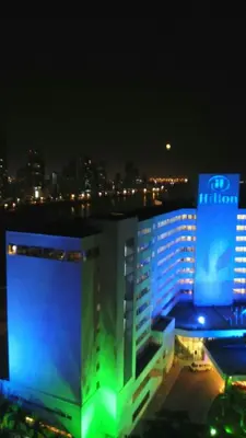 a large building with a sign on it at night at Apartamentos Cartagena in Cartagena de Indias