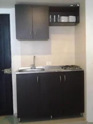 a kitchen with black cabinets and a sink at Apartamentos Cartagena in Cartagena de Indias