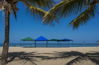 a group of umbrellas on a beach with the ocean at Cabaña Coveñas in Coveñas