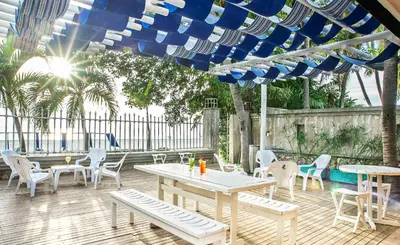 a patio with tables and chairs under a blue umbrella at Santorini Villas Santa Marta in Santa Marta