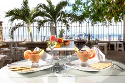 a table with two plates of food and glasses of wine at Santorini Villas Santa Marta in Santa Marta