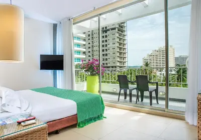 a bedroom with a bed and a large window at Hotel Santorini Resort in Santa Marta