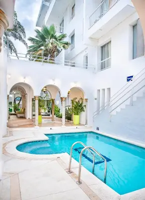 a swimming pool in the courtyard of a building at Hotel Santorini Resort in Santa Marta