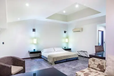 a bedroom with a bed and a table and chairs at Hotel Santorini Express y Cabañas in Santa Marta