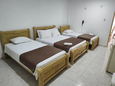 two twin beds in a room with at Hotel Ginebra Sincelejo in Sincelejo