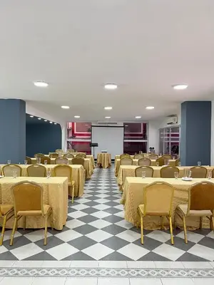 a large room with tables and chairs and a screen at Hotel Casa Ballesteros in Barranquilla