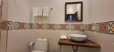 a bathroom with a sink and a mirror and a toilet at Hotel Casa de Las Palmas in Cartagena de Indias