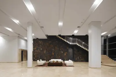 a large room with white chairs and a staircase at Estelar Apartamentos Barranquilla in Barranquilla