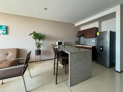 a kitchen with a counter and a table and chairs at Estelar Apartamentos Barranquilla in Barranquilla
