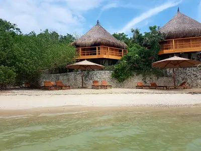 a resort with chairs and umbrellas on the beach at Hotel Las Islas in Baru