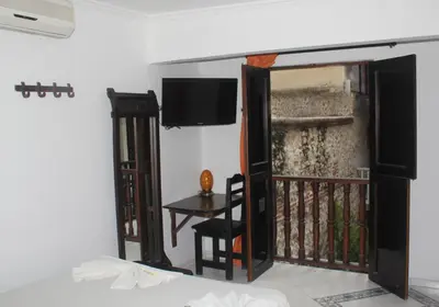 a room with a balcony with a tv and a door at Hotel Villa Colonial By Akel Hotels in Cartagena de Indias
