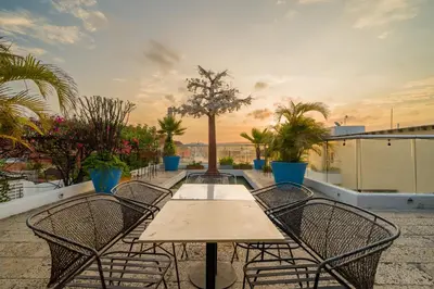 a patio with a table and chairs on a roof at Nacar Hotel Cartagena, Curio Collection by Hilton in Cartagena de Indias
