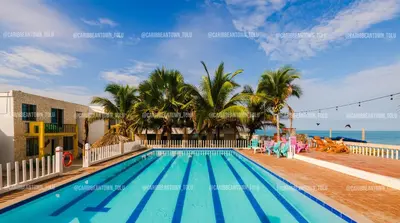 a swimming pool with the beach in the background at Caribbean Town Tolu in Tolú