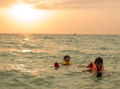 two children playing in the water in the ocean at Raw KokoMar CasaNativa in Baru