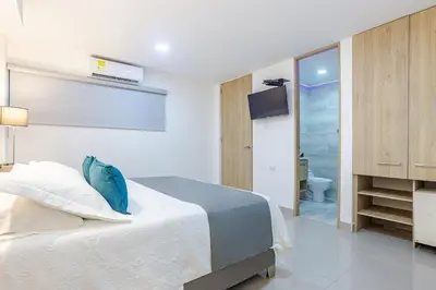 a bedroom with a bed and a television and a bathroom at Hotel Ancor in Sincelejo