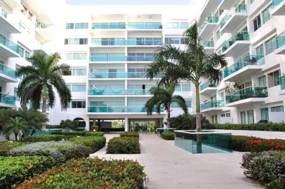 a large apartment building with palm trees and a courtyard at Apartamentos Morros Cartagena in Cartagena de Indias