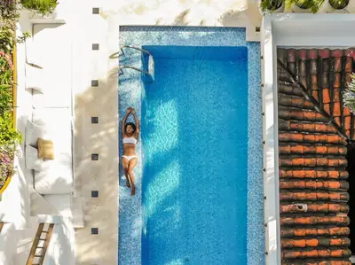 a woman is swimming in a swimming pool at Amarla Boutique Hotel Cartagena in Cartagena de Indias
