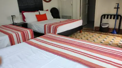a hotel room with two beds with striped sheets at La casa azul in Cartagena de Indias