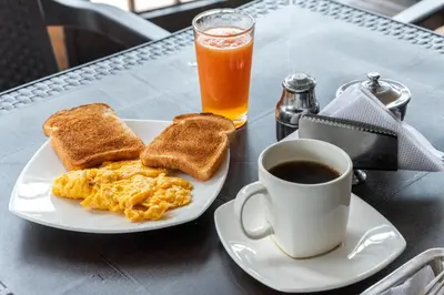 a plate of eggs and toast and a cup of coffee at Ayenda 1801 El Oceano in Cartagena de Indias