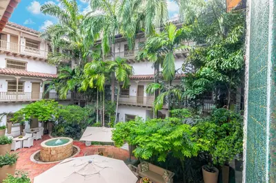 an outdoor patio with umbrellas in front of a building at GHL Collection Armería Real Hotel in Cartagena de Indias