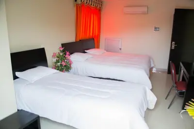 two beds in a hotel room with white sheets at Hotel Continental Express in Barranquilla