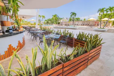 an outdoor patio with tables and chairs and plants at Sonesta Hotel Cartagena in Cartagena de Indias