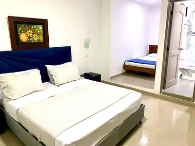 a bedroom with a bed with a blue headboard at Hotel Yivinaca in Barranquilla