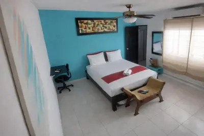 a bedroom with a bed and a blue wall at QuillaHost Tropical Apartment in Barranquilla