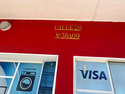 a sign on the side of a building with a cell phone at Hotel Troncal Del Caribe in Ciénaga