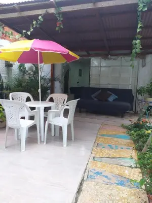 a patio with a table and chairs and an umbrella at Villa mar in Puerto Colombia