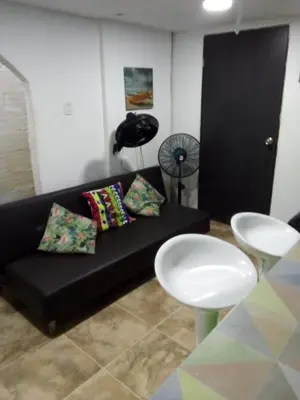 a living room with a black couch and a table at Villa mar in Puerto Colombia