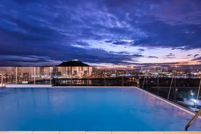 a swimming pool at night with a view of a city at Holiday Inn Express Cartagena Manga by IHG in Cartagena de Indias