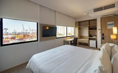 a bedroom with a white bed and two large windows at Holiday Inn Express Cartagena Manga by IHG in Cartagena de Indias
