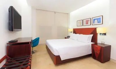a hotel room with a bed and a flat screen tv at NH Royal Urban Cartagena in Cartagena de Indias