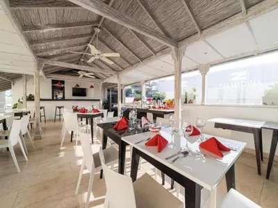 a dining room with tables and white chairs at Zalmedina Hotel in Cartagena de Indias