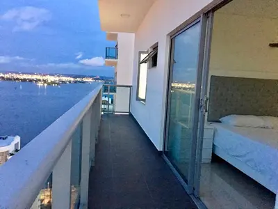 a balcony with a bed and a view of the ocean at luxuriuso apartament in Cartagena de Indias