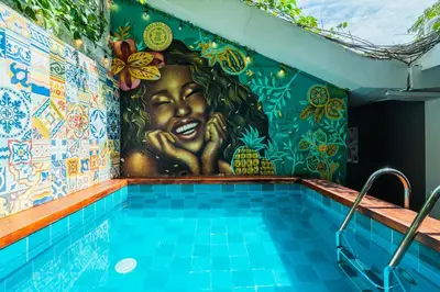 a swimming pool with a mural of a woman at Casa Del Pozo Boutique - Full House in Cartagena de Indias
