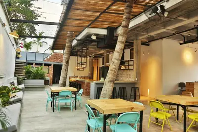 a patio with tables and chairs and a bar at Santuario Getsemani Hostel in Cartagena de Indias