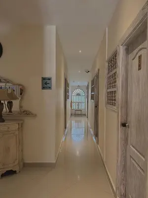 a hallway with white walls and a long hallway with a door at Hotel La Magdalena in Cartagena de Indias